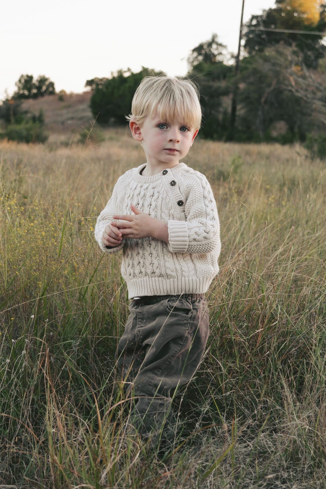 Toddler standing in tall grass